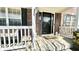 Up close shot of an inviting covered porch with a welcome sign and comfortable seating, decorated with flowers at 5941 Bonneville Way, Indianapolis, IN 46237