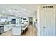 Bright kitchen with large island, granite countertops, stainless appliances, and adjacent pantry door at 5941 Bonneville Way, Indianapolis, IN 46237