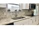 Close up on the kitchen sink showcasing the granite countertops and herringbone backsplash at 5941 Bonneville Way, Indianapolis, IN 46237
