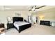 A spacious main bedroom with neutral colors, dark wood furniture, a ceiling fan, and lots of light at 5941 Bonneville Way, Indianapolis, IN 46237