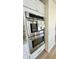 Close up of stainless steel double ovens with white cabinets and granite countertops at 5941 Bonneville Way, Indianapolis, IN 46237