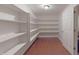 Walk-in pantry with white shelving, hardwood floors, and ample storage space at 5941 Bonneville Way, Indianapolis, IN 46237