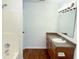 Bathroom with tiled shower, vanity with sink, and wood-look floors, well-lit with sconce lighting at 6191 E Ayrshire Cir, Camby, IN 46113