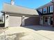 Attached two-car garage featuring paneled doors and modern exterior lighting at 6191 E Ayrshire Cir, Camby, IN 46113
