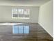 Bright, spacious living room with grey flooring and a large window providing plenty of natural light at 6191 E Ayrshire Cir, Camby, IN 46113