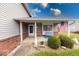 Close up of charming covered porch with an American flag and beautifully landscaped bushes at 628 Southridge Ct, Westfield, IN 46074