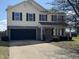 Two-story home with a brick and vinyl exterior and a two-car garage and a well manicured lawn at 6417 E Clarks Hill Ct, Camby, IN 46113