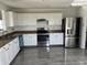 Bright kitchen with white cabinets, stainless steel appliances, and modern fixtures with gray wood floors at 6417 E Clarks Hill Ct, Camby, IN 46113