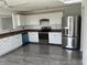 Bright kitchen with white cabinets, stainless steel appliances, and modern fixtures with gray wood floors at 6417 E Clarks Hill Ct, Camby, IN 46113