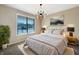 Serene main bedroom featuring a large window, modern light fixture, and neutral tones at 643 Bracknell Dr, Avon, IN 46123