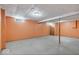 Unfinished basement with concrete ceiling, carpeted flooring and painted orange walls at 6602 Boston Ridge Ct, Indianapolis, IN 46237