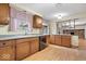 Charming kitchen featuring wood cabinets, laminate flooring, and a view into the adjacent living area at 6602 Boston Ridge Ct, Indianapolis, IN 46237