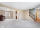 Open-concept living room featuring neutral carpet, a large window, and staircase access at 6602 Boston Ridge Ct, Indianapolis, IN 46237