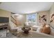 Inviting living room featuring staircase, plush seating, and a large window for natural light at 6602 Boston Ridge Ct, Indianapolis, IN 46237