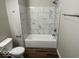 Full bathroom with tiled walls and a built-in tub at 709 S Vine St, Muncie, IN 47302