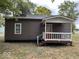 The rear exterior of the home features neutral siding and a charming covered back porch at 709 S Vine St, Muncie, IN 47302