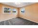 A bright bedroom featuring three windows and plush gray carpeting at 7224 Rose Dr, Indianapolis, IN 46227