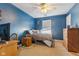 Comfortable bedroom with blue walls, carpet, ceiling fan, and natural light at 76 Wyndham Ln, Brownsburg, IN 46112