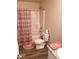 Bathroom features a tub and shower combination with pink curtain, toilet, and vanity at 7835 E 296Th St, Atlanta, IN 46031