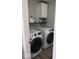 Functional laundry room equipped with modern washer and dryer units, shelving, and storage cabinet at 7835 E 296Th St, Atlanta, IN 46031