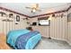 Charming bedroom with striped walls, ceiling fan, and a bright blue bedspread at 9053 Sunset Ln, Brownsburg, IN 46112