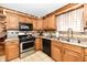 Traditional kitchen with stainless steel appliances, wooden cabinets and tile flooring at 9053 Sunset Ln, Brownsburg, IN 46112