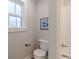 Small bathroom with a toilet, artwork, and a window providing natural light at 9184 Anthem Ave, Plainfield, IN 46168
