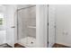 Modern tiled shower stall with glass doors, plus a glimpse into an adjacent bedroom at 9198 Anthem Ave, Plainfield, IN 46168