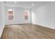 Sunlit bedroom with wood floors, white walls, and two windows providing natural light at 9198 Anthem Ave, Plainfield, IN 46168