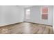 Bright bedroom featuring hardwood floors, neutral walls and trim, and natural light from two windows at 9198 Anthem Ave, Plainfield, IN 46168