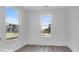 Sunlit bedroom with large windows offering views of the neighborhood and gray flooring at 9198 Anthem Ave, Plainfield, IN 46168