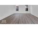Bright living room featuring wood-look floors, white walls, and two large windows at 9198 Anthem Ave, Plainfield, IN 46168