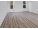 Bright living room showcasing wood-look floors, white walls, and large windows at 9198 Anthem Ave, Plainfield, IN 46168