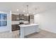 Bright, open-concept kitchen featuring a large island, stainless steel appliances, and dark wood cabinetry at 9210 Anthem Ave, Plainfield, IN 46168