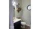 Well-lit half bathroom featuring a modern vanity, decorative mirror, and stylish fixtures at 943 Rushmore Dr, Pittsboro, IN 46167