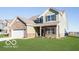 A beautiful two-story home featuring green siding, brick details, and a spacious front lawn at 943 Rushmore Dr, Pittsboro, IN 46167