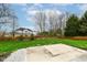 Large grassy backyard with a wooden fence, mature trees and a concrete patio at 10580 Saddlestone Dr, Fishers, IN 46040