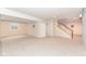 Spacious basement with carpet flooring and stairs to the main level at 10580 Saddlestone Dr, Fishers, IN 46040