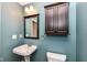 Bathroom with a pedestal sink, dark framed mirror, and a dark colored medicine cabinet at 10580 Saddlestone Dr, Fishers, IN 46040