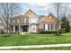 Charming two-story home showcases a well-manicured lawn, brick facade, and cedar accents at 10580 Saddlestone Dr, Fishers, IN 46040
