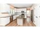 White kitchen showcasing granite counters, island, stainless steel appliances, and wood floors at 10580 Saddlestone Dr, Fishers, IN 46040