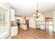 Well-lit kitchen with stainless steel appliances, island, granite countertops, and wood flooring at 10580 Saddlestone Dr, Fishers, IN 46040