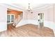 Open-concept living room with hardwood floors, decorative moldings, and chandelier at 10580 Saddlestone Dr, Fishers, IN 46040