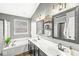 Bathroom with double vanity, large mirror, garden tub, and a window at 11789 Langham Crescent Ct, Fishers, IN 46037