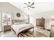 Bright bedroom with a wooden bed, ceiling fan, hardwood floors, and large windows at 11789 Langham Crescent Ct, Fishers, IN 46037
