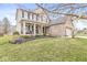 Charming two-story home boasts a welcoming front porch, manicured lawn, and attached garage, offering curb appeal at 11789 Langham Crescent Ct, Fishers, IN 46037