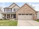 Charming two-story home featuring a brick facade, attached two-car garage, and a well-manicured front lawn at 11789 Langham Crescent Ct, Fishers, IN 46037