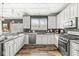 Eat-in kitchen featuring granite counters, stainless appliances, white cabinets, hardwood floors, and recessed lighting at 11789 Langham Crescent Ct, Fishers, IN 46037