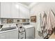 Laundry room featuring white cabinets, white subway tile, art, and white washer and dryer units at 11789 Langham Crescent Ct, Fishers, IN 46037