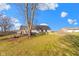 View of the home's backyard with mature tree, wood deck and expansive lawn at 1243 S Morristown Pike, Greenfield, IN 46140